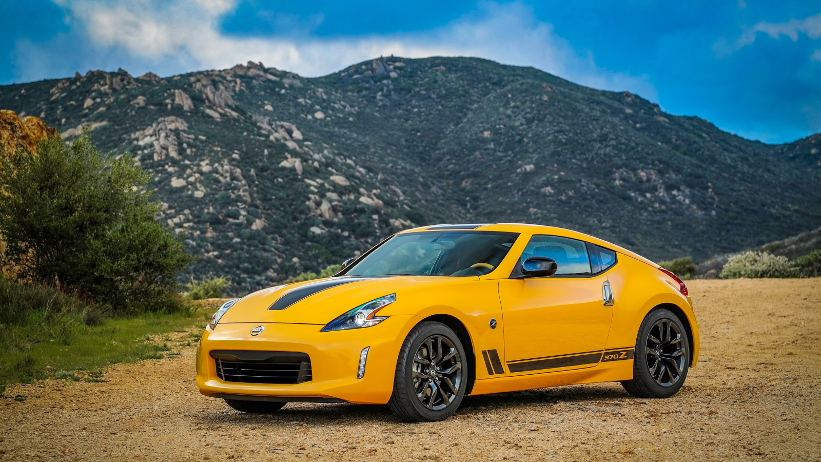 Желтый автомобиль Nissan 370Z Heritage Edition, 2018 на фоне гор