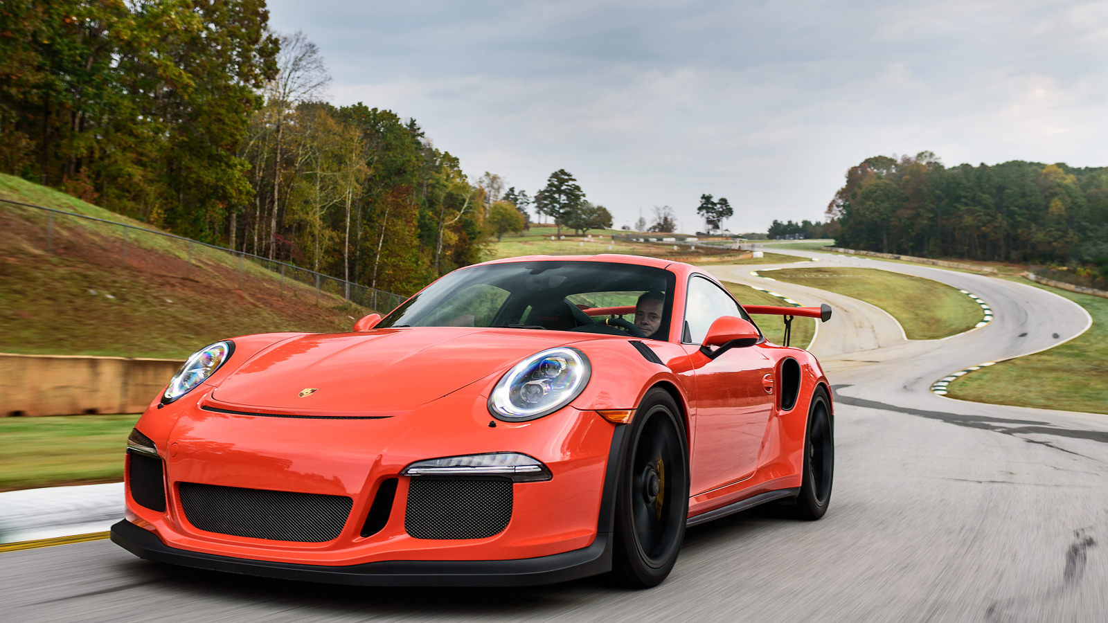 Оранжевый спортивный автомобиль Porsche 911 GT3 на трассе
