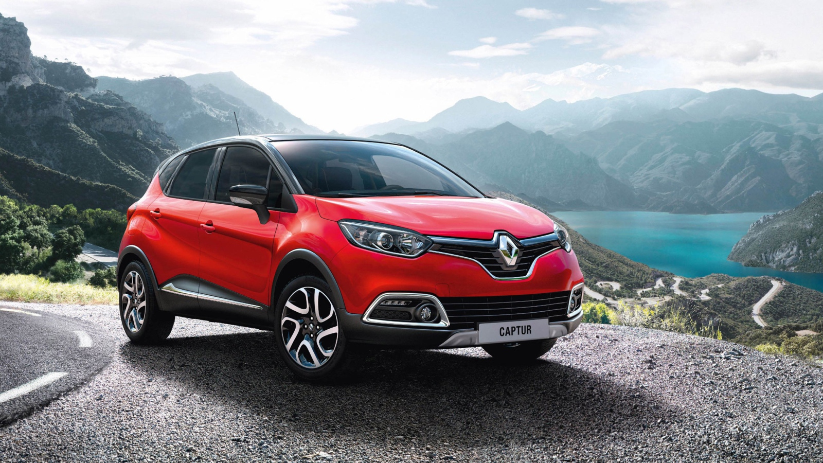Красный автомобиль внедорожник Renault Captur на фоне гор