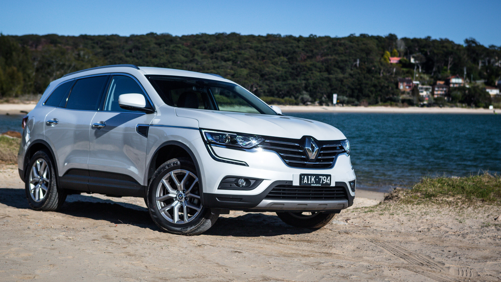 Белый автомобиль Renault Koleos у водоема