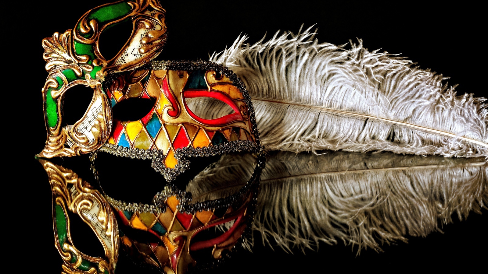 Две красивые маскарадные маски с пером на черном фоне