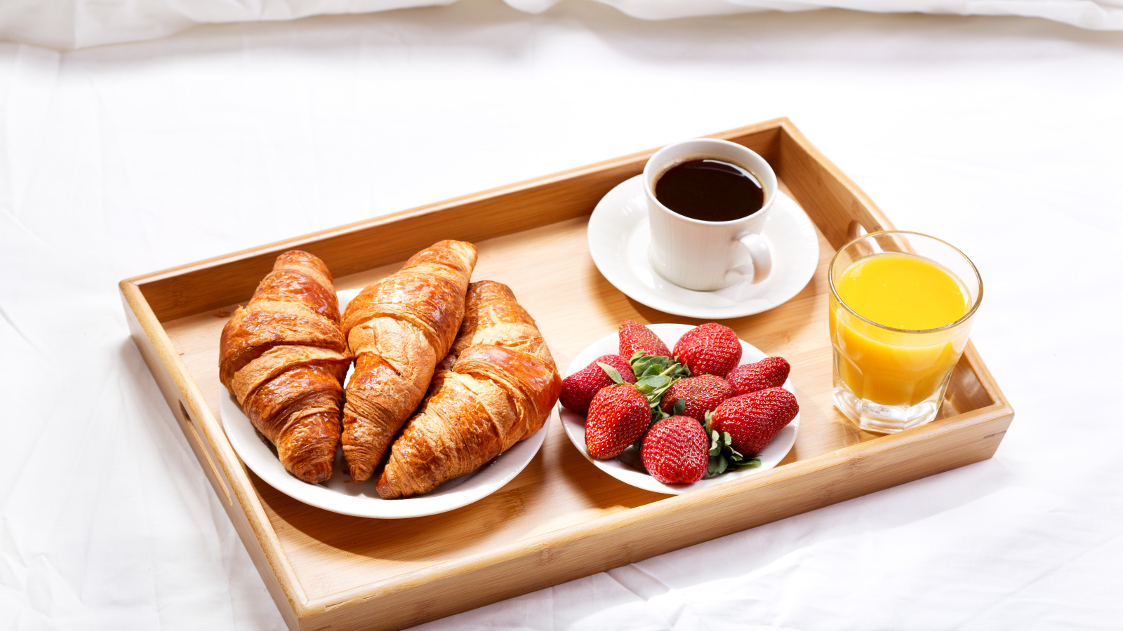 Круассаны, клубника, апельсиновый сок и кофе на завтрак