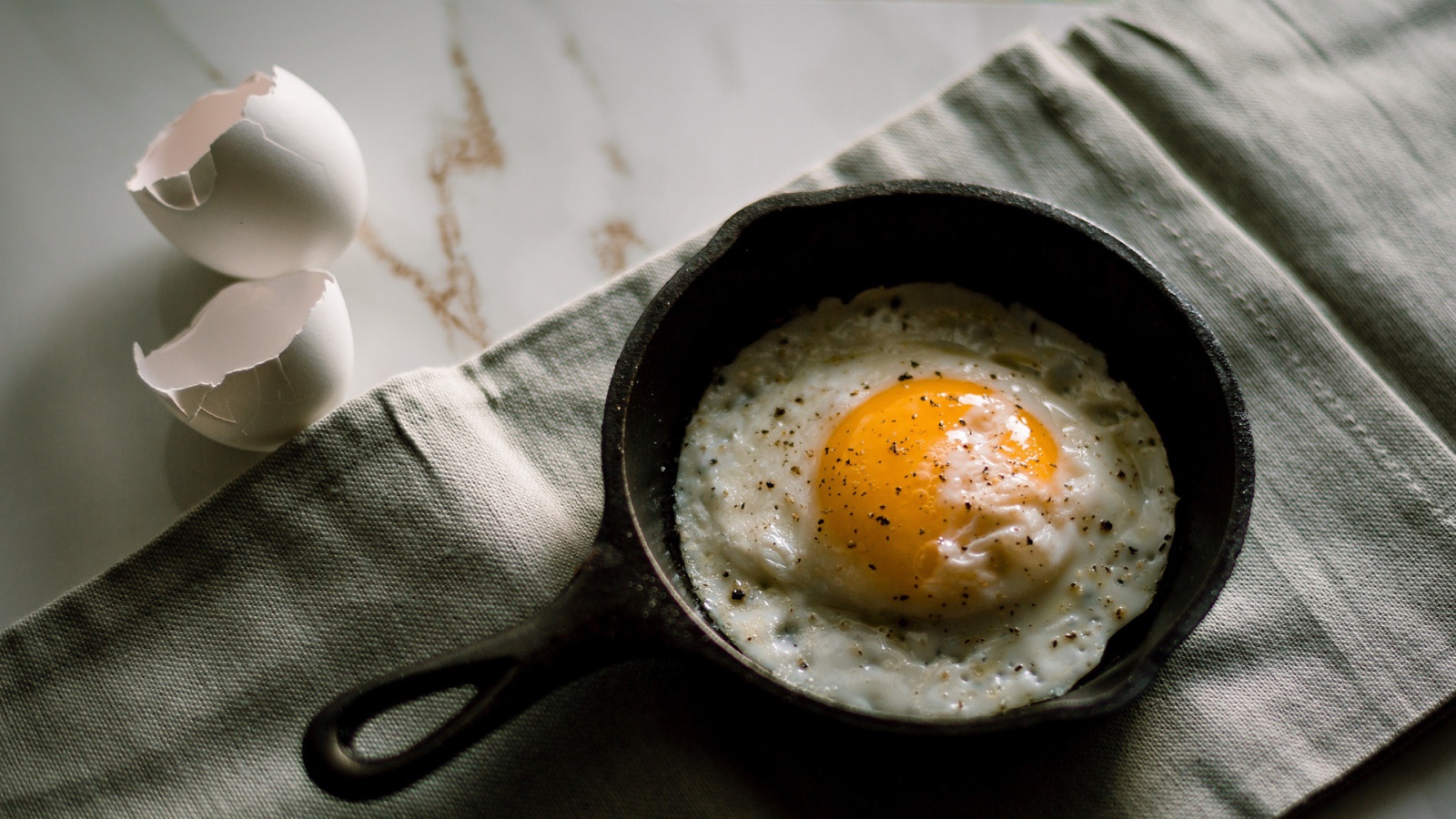 Яичница глазунья на столе в маленькой сковороде
