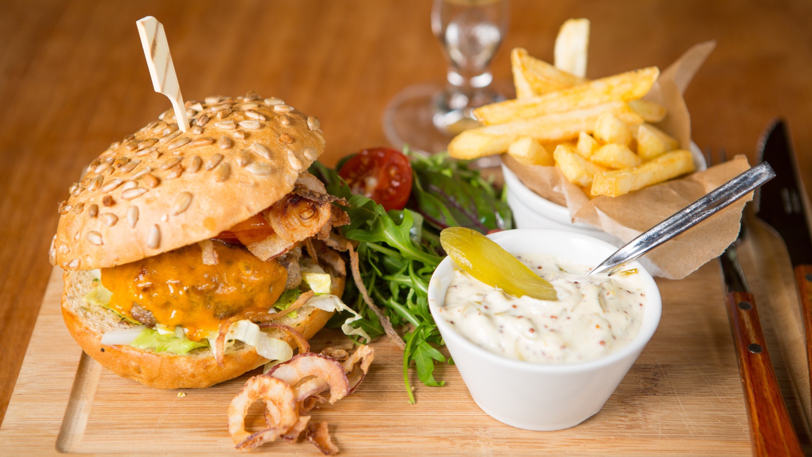 Гамбургер и картошка фри на столе с соусом