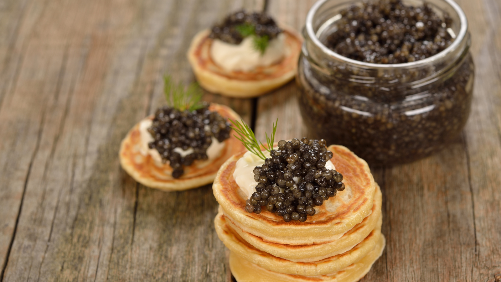 Оладьи с икрой и зеленью на столе