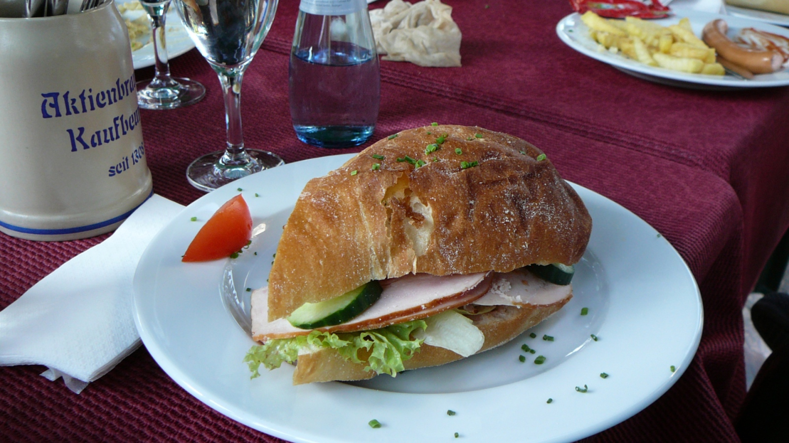 Сэндвич с ветчиной и овощами на столе в ресторане
