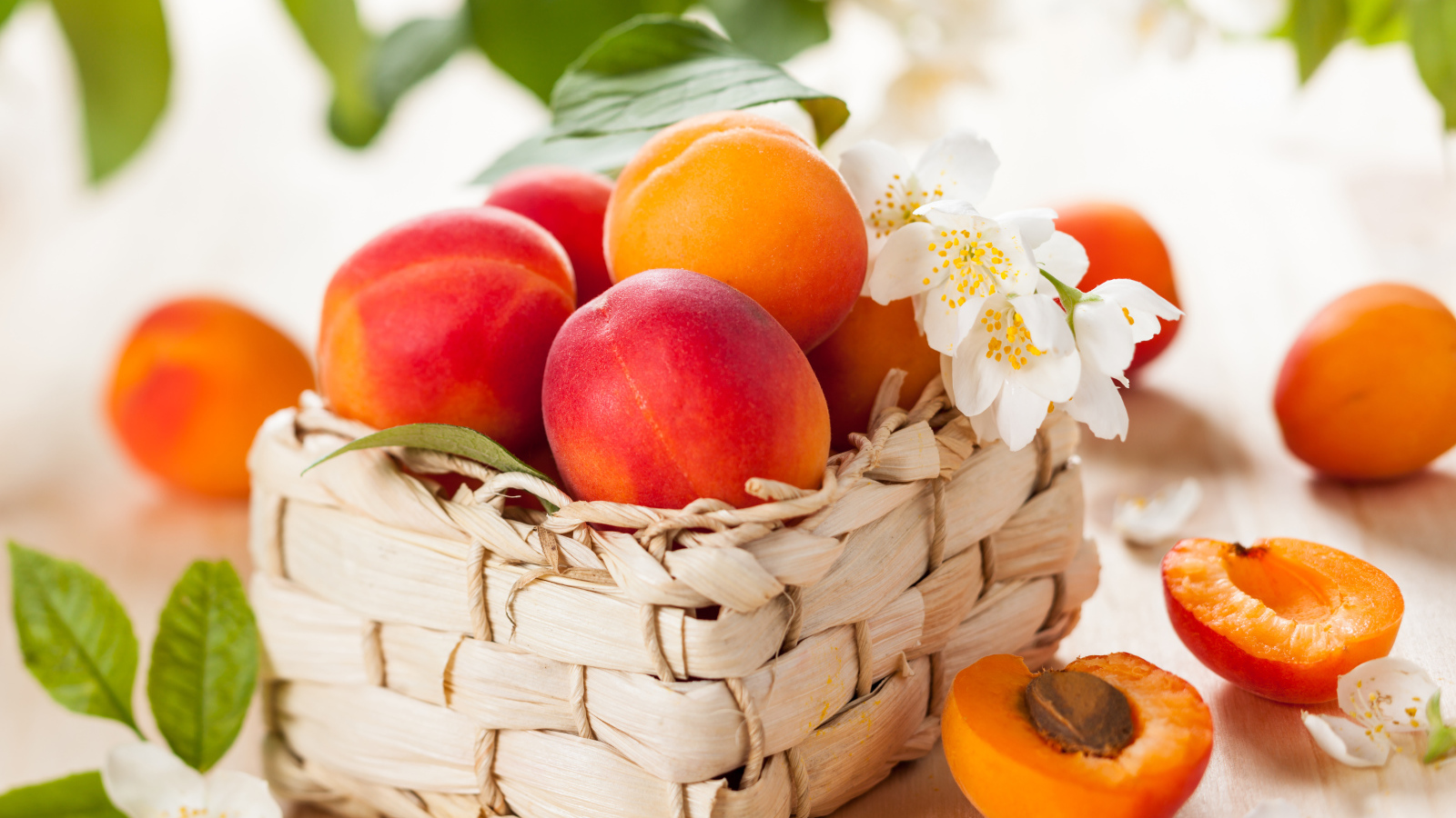Аппетитные спелые персики в корзине на столе