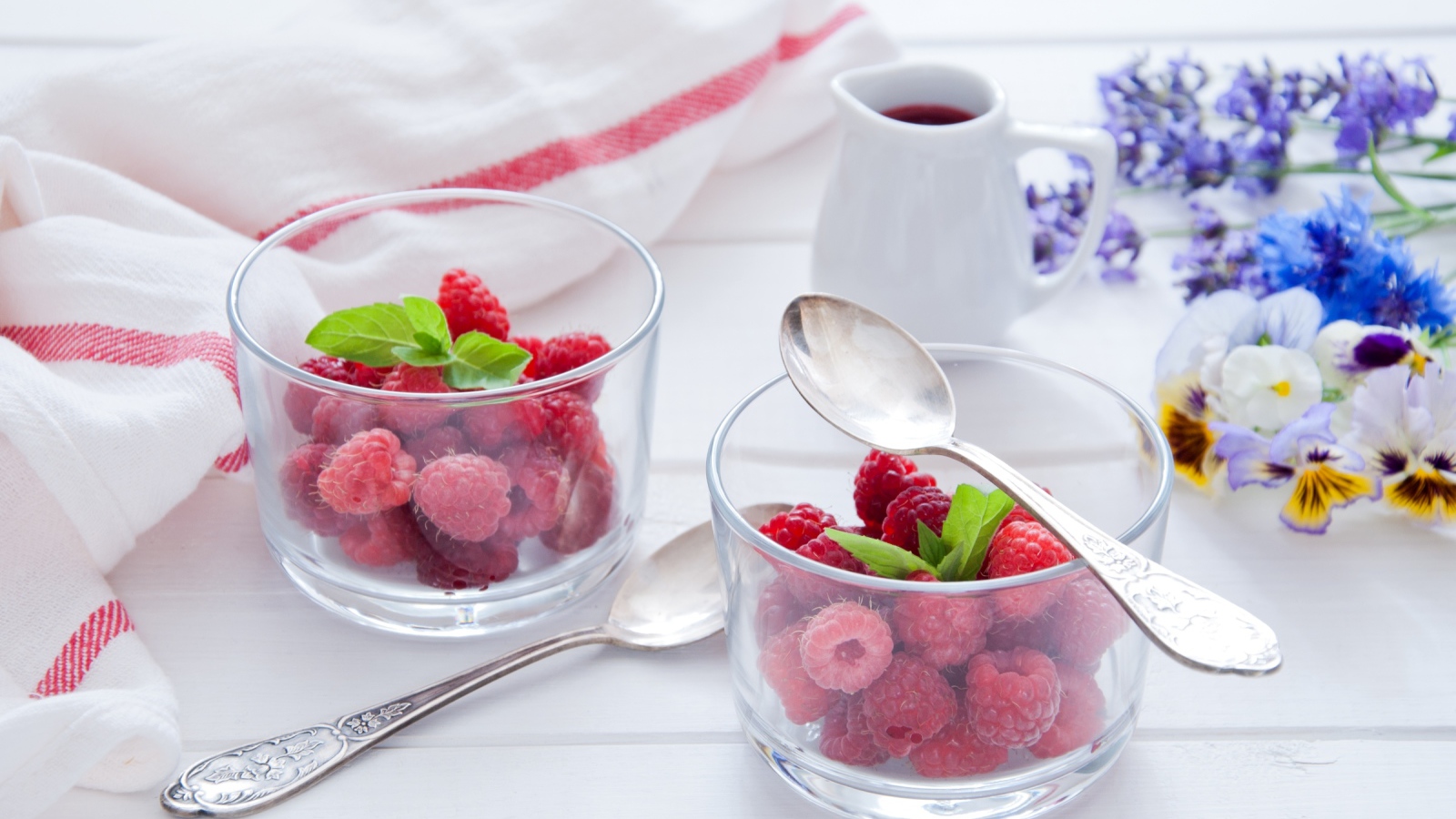 Малина в прозрачный стаканах на завтрак на столе