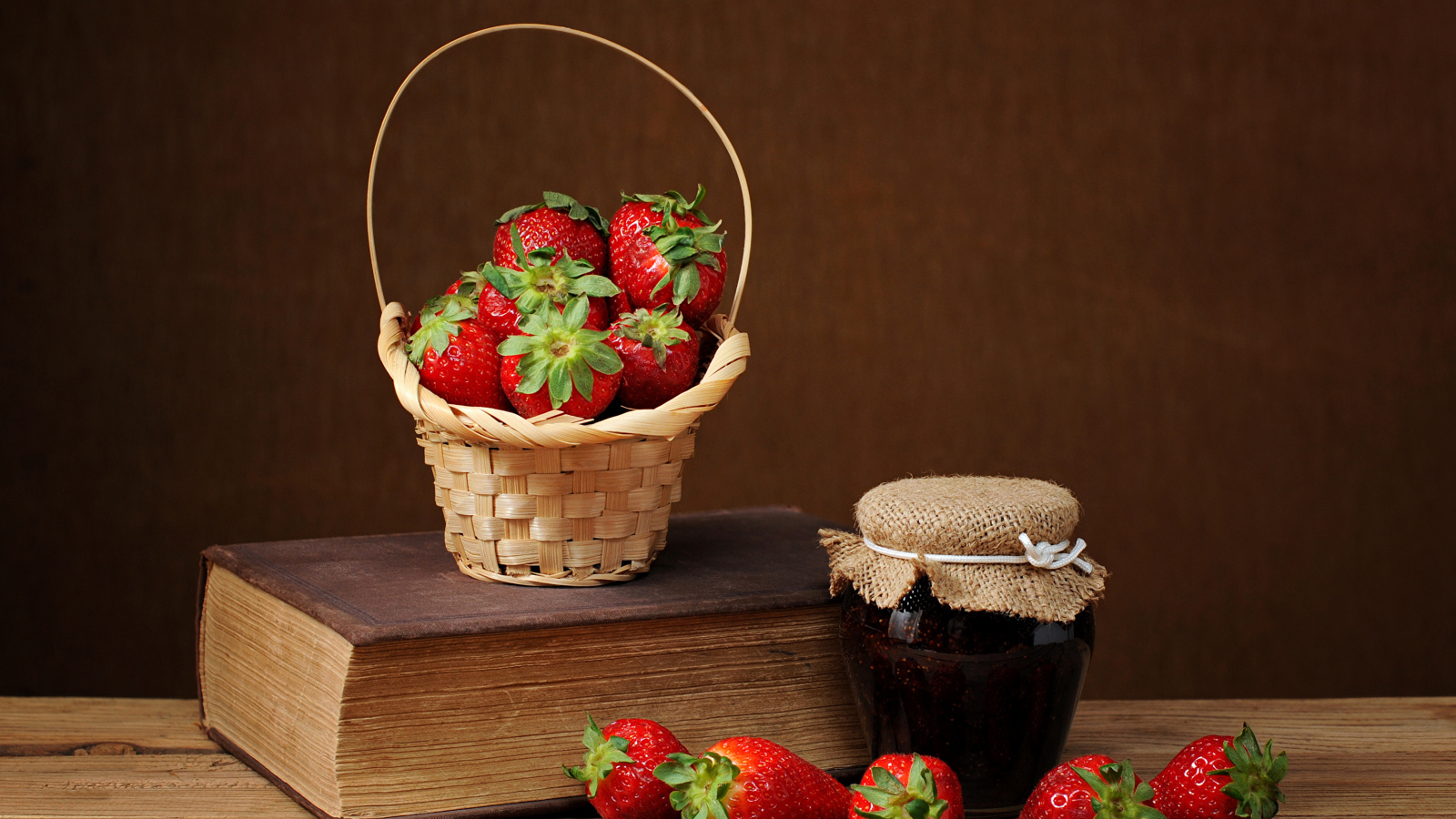 Клубничный джем, свежая клубника и книга на столе