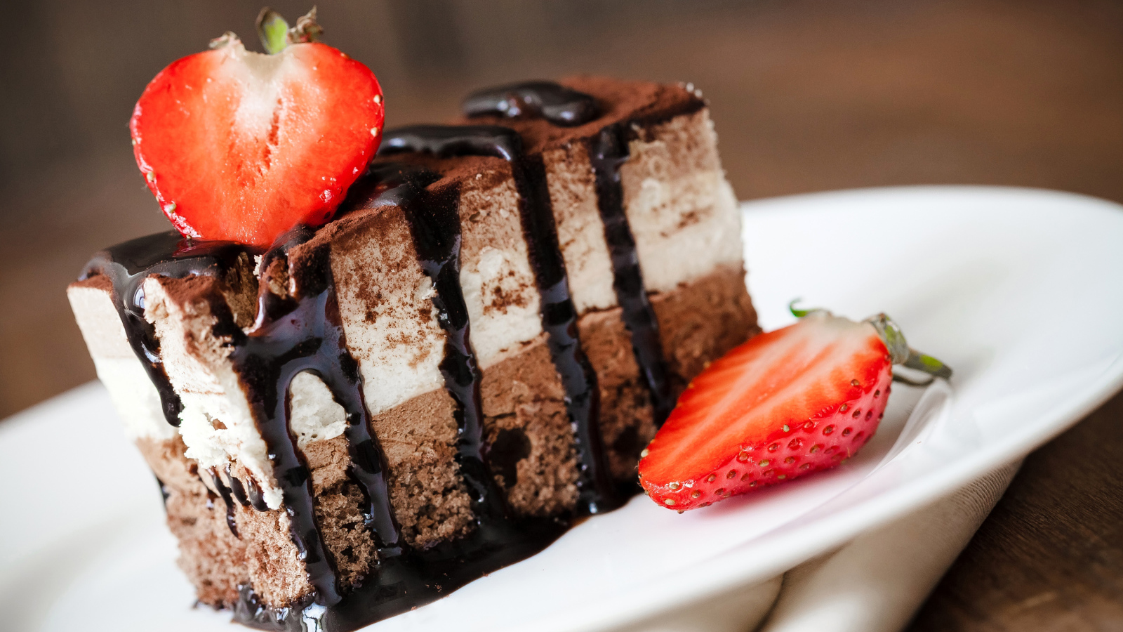 Кусок шоколадного пирожного со свежей клубникой