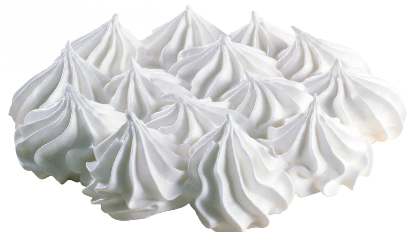 Воздушные взбитые сливки на белом фоне