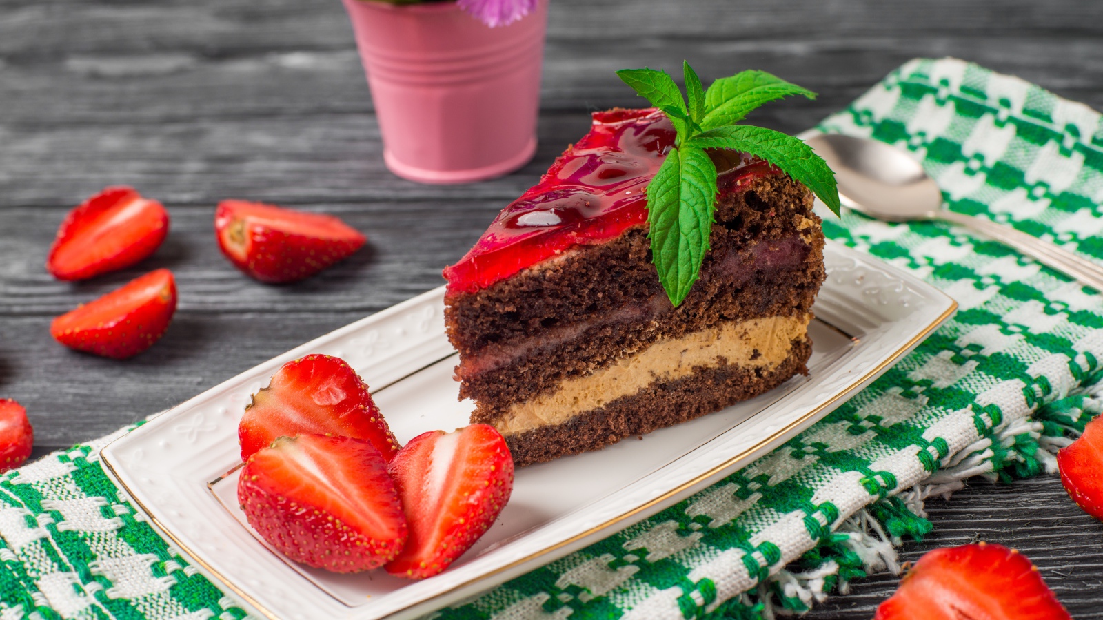 Аппетитный кусок торта на тарелке с ягодами клубники