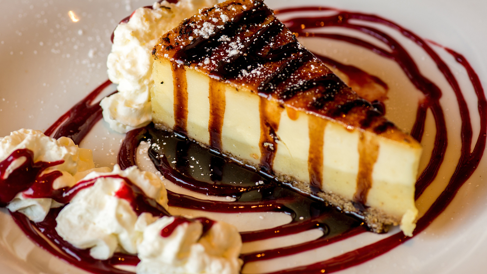 Аппетитный кусок чизкейка со сливками и клубничным джемом