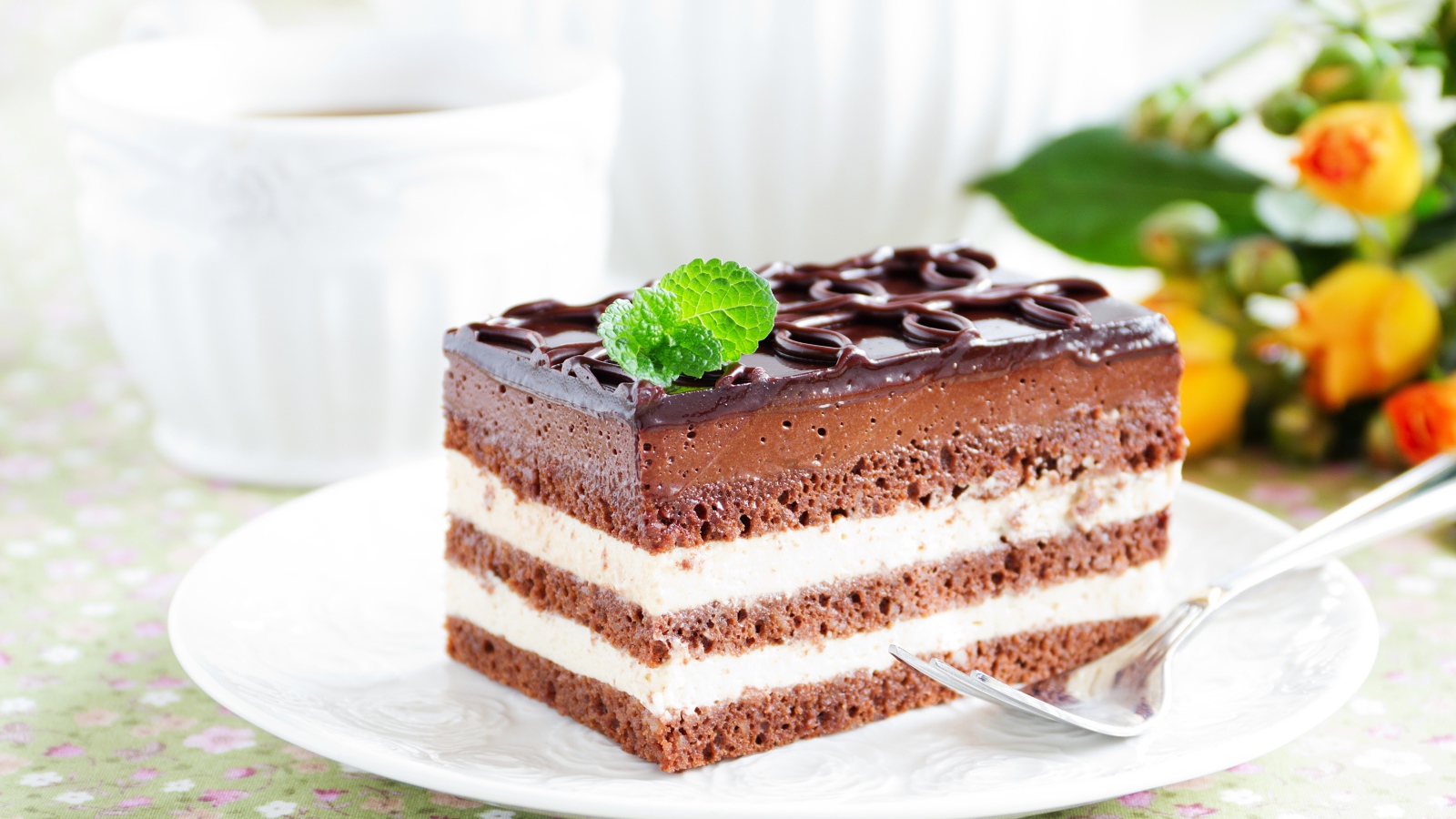 Пирожное с шоколадным и сливочным кремом на белой тарелке