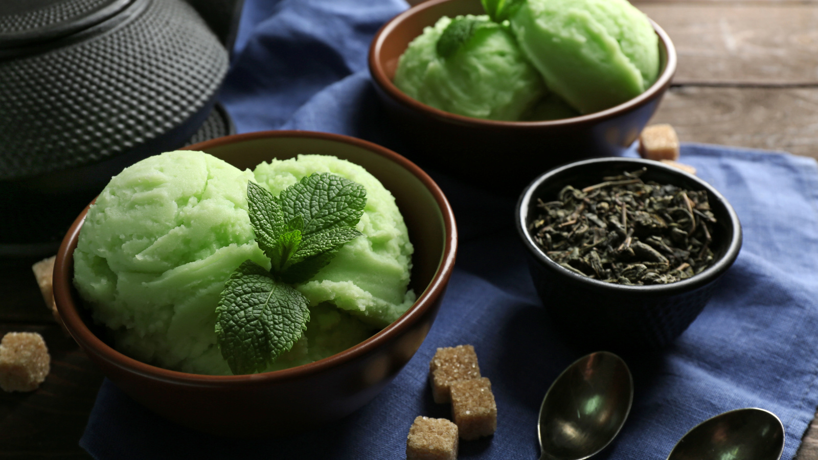 Зеленое мятное мороженое и кусочки сахара на столе 