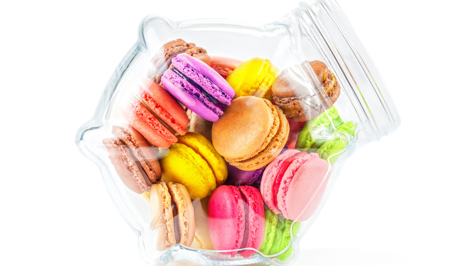 Разноцветные макаруны в стеклянной банке на белом фоне