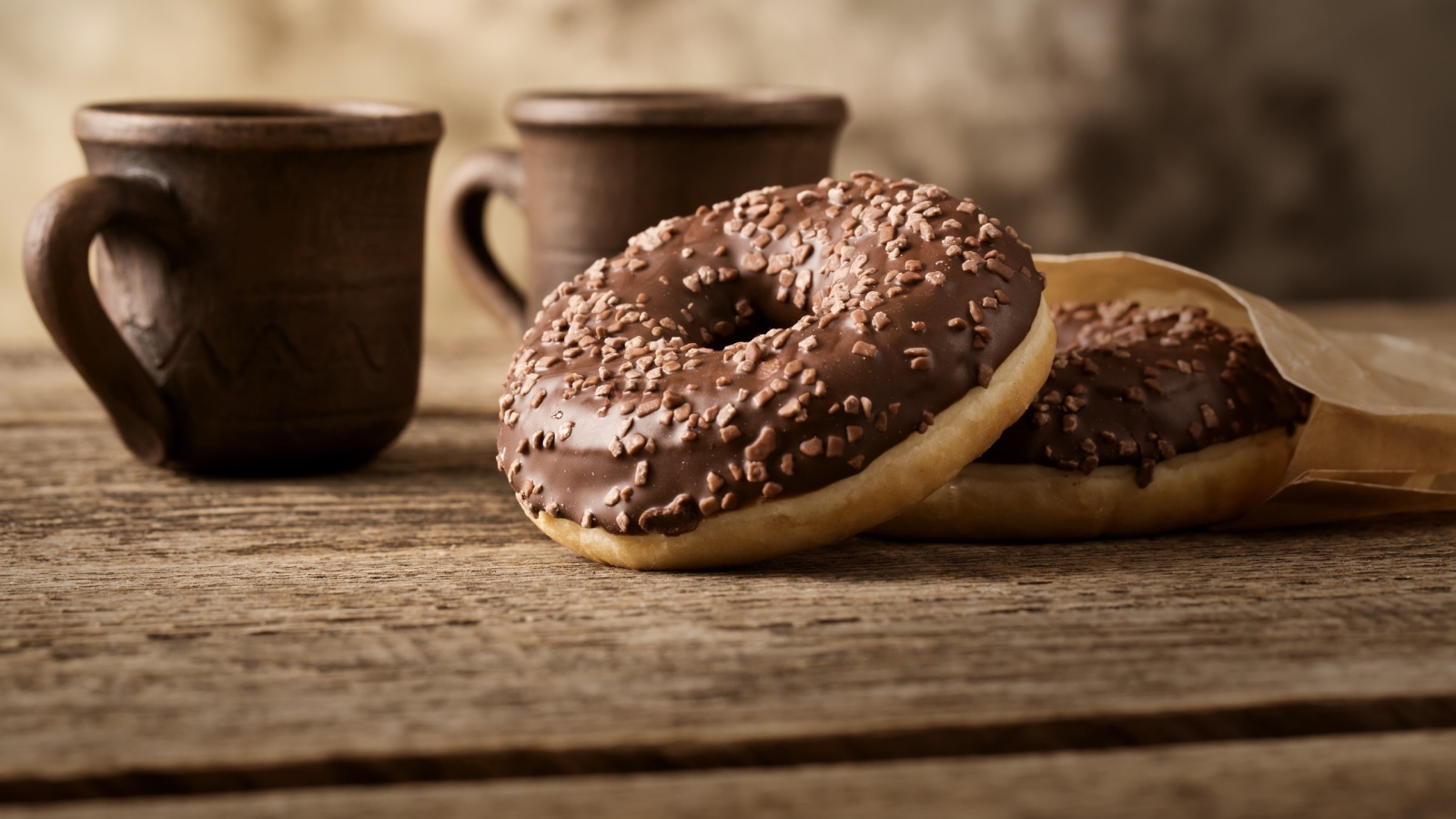 Сладкие круглые пончики с шоколадом на столе 