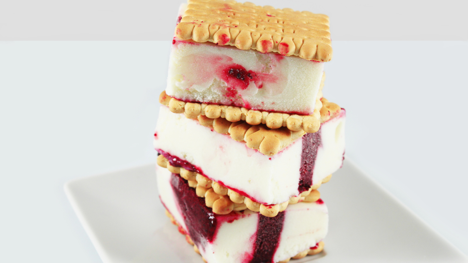 Три кусочка мороженого с печеньем на сером фоне