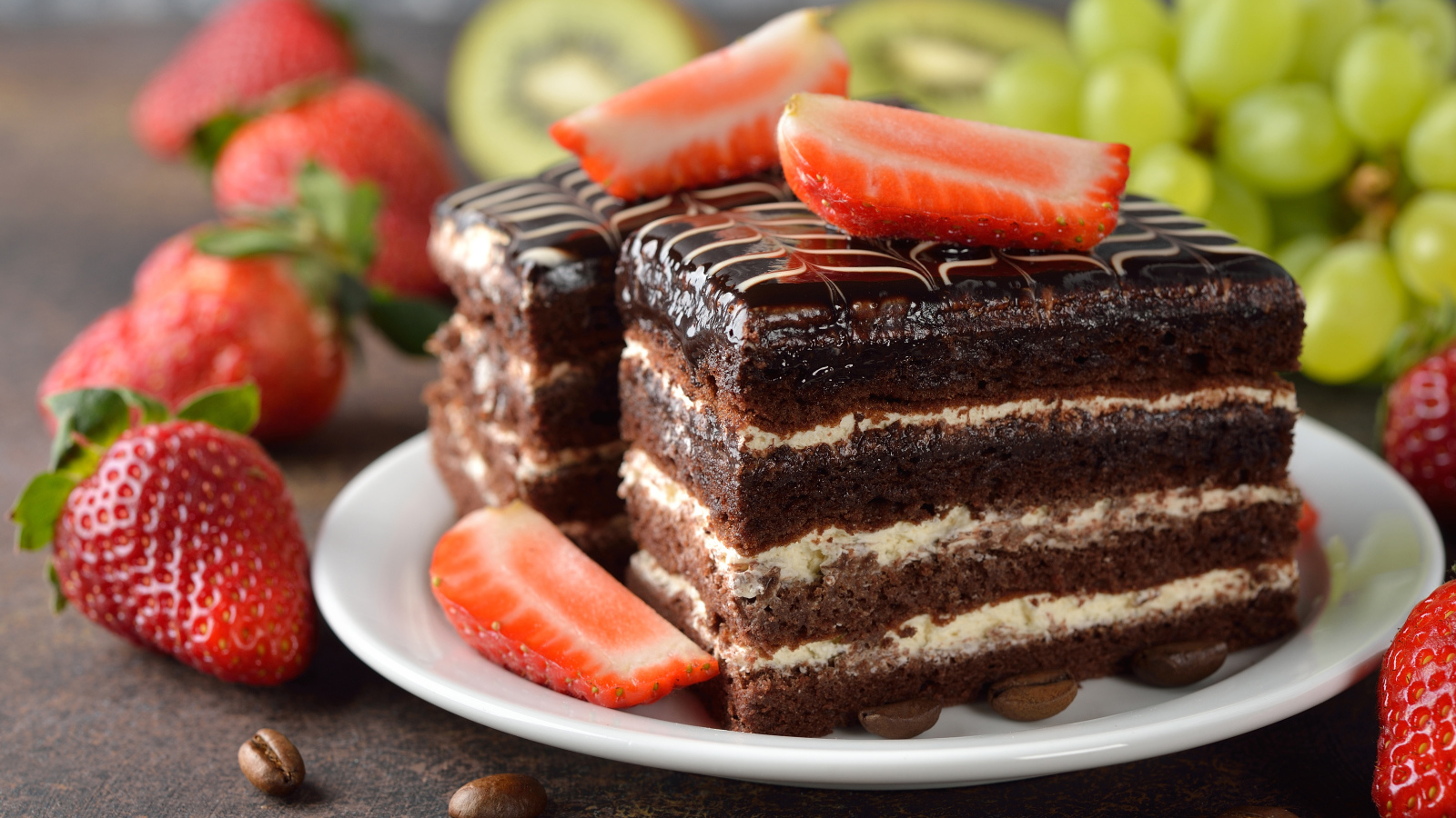 Два кусочка шоколадного пирожного с ягодами клубники