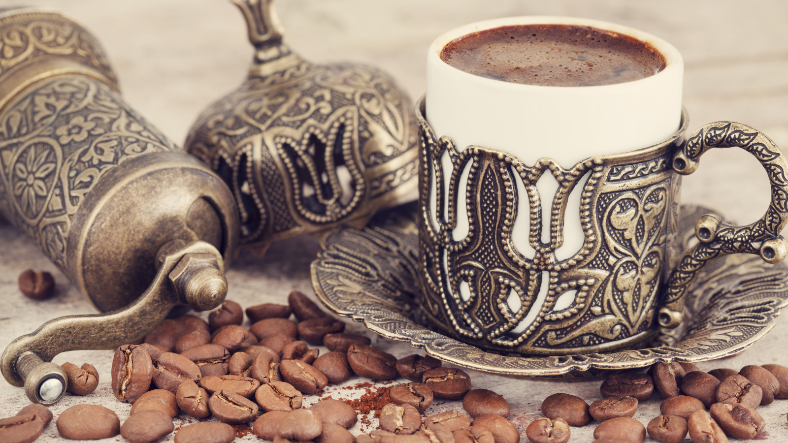 Вкусный кофе в красивой чашке с кофейными зернами на столе