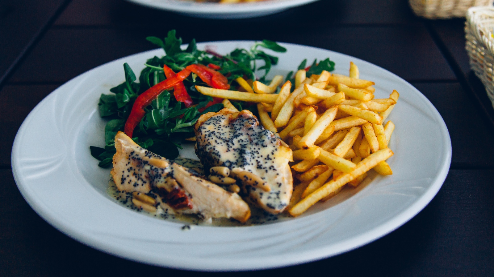 Курица с картофелем фри и салатом на большой белой тарелке