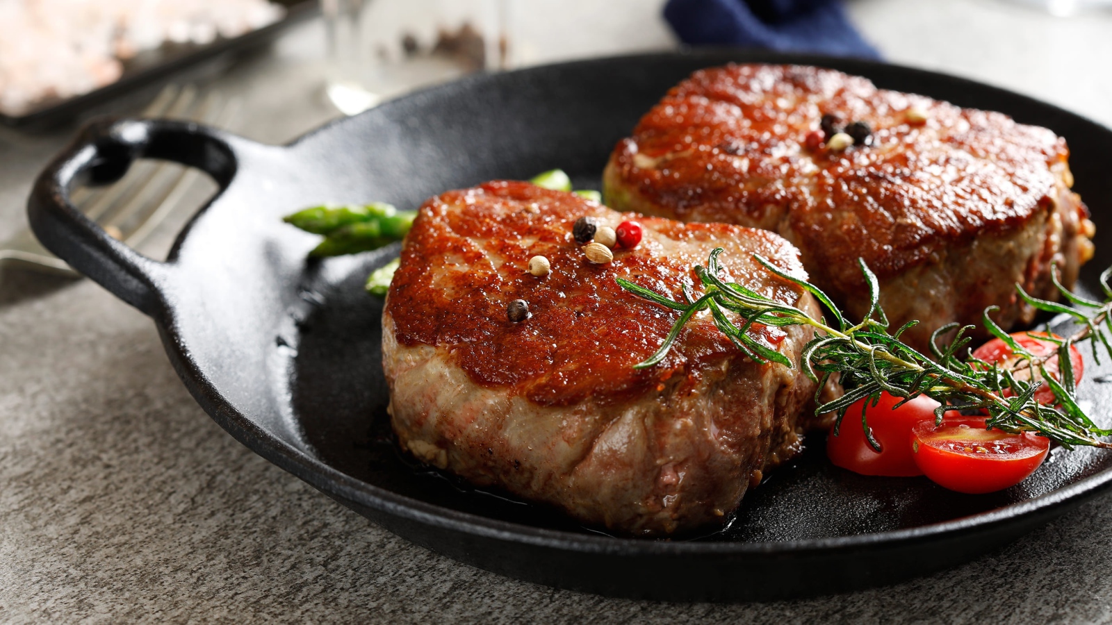 Два аппетитных сочных куска мяса с помидорами и розмарином