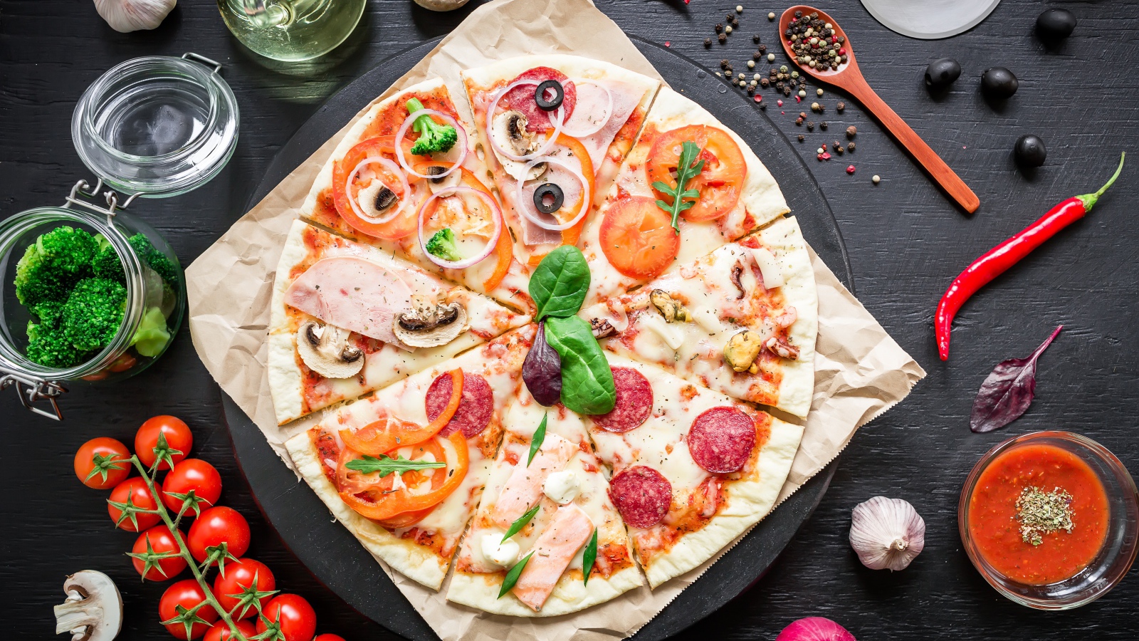 Аппетитная пицца на столе со специями и помидорами