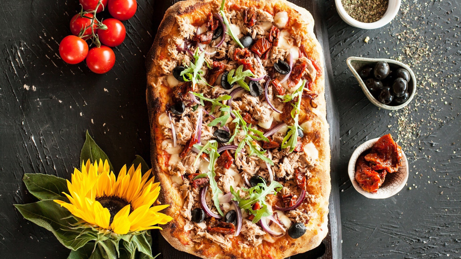 Жареная пицца с мясом на столе с желтым цветком подсолнуха