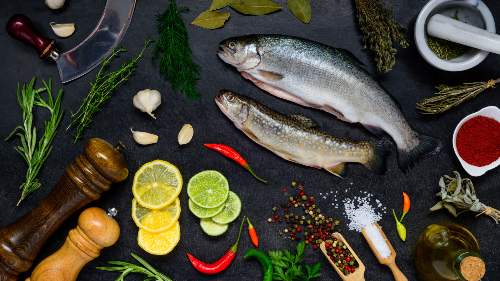 Сырая рыба на столе со специями и лимонами