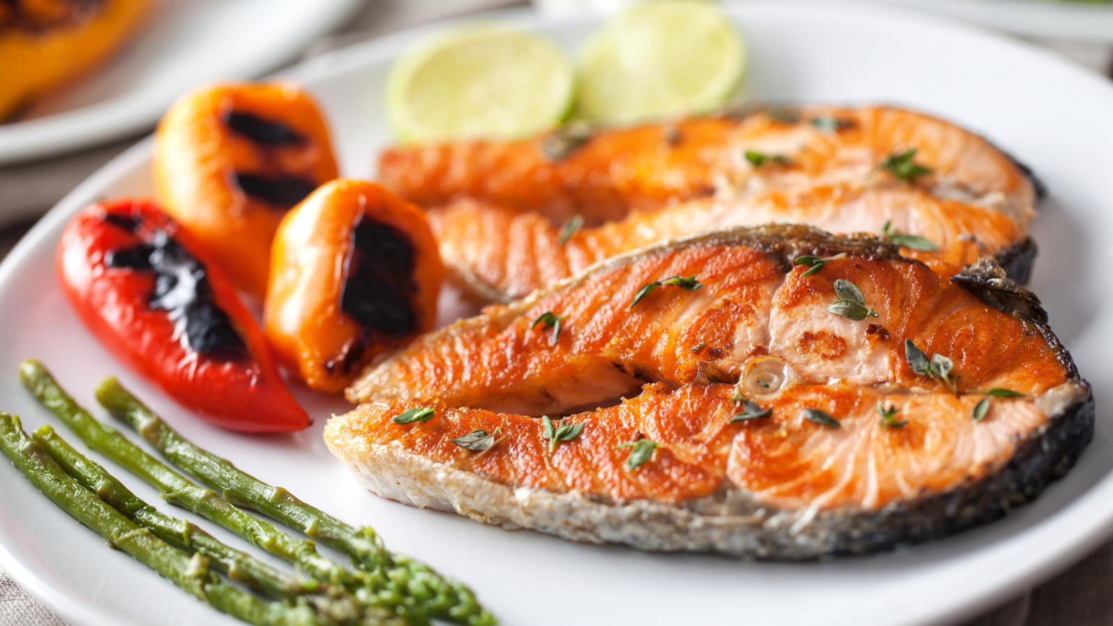 Два кусочка жареной красной рыбы с овощами 