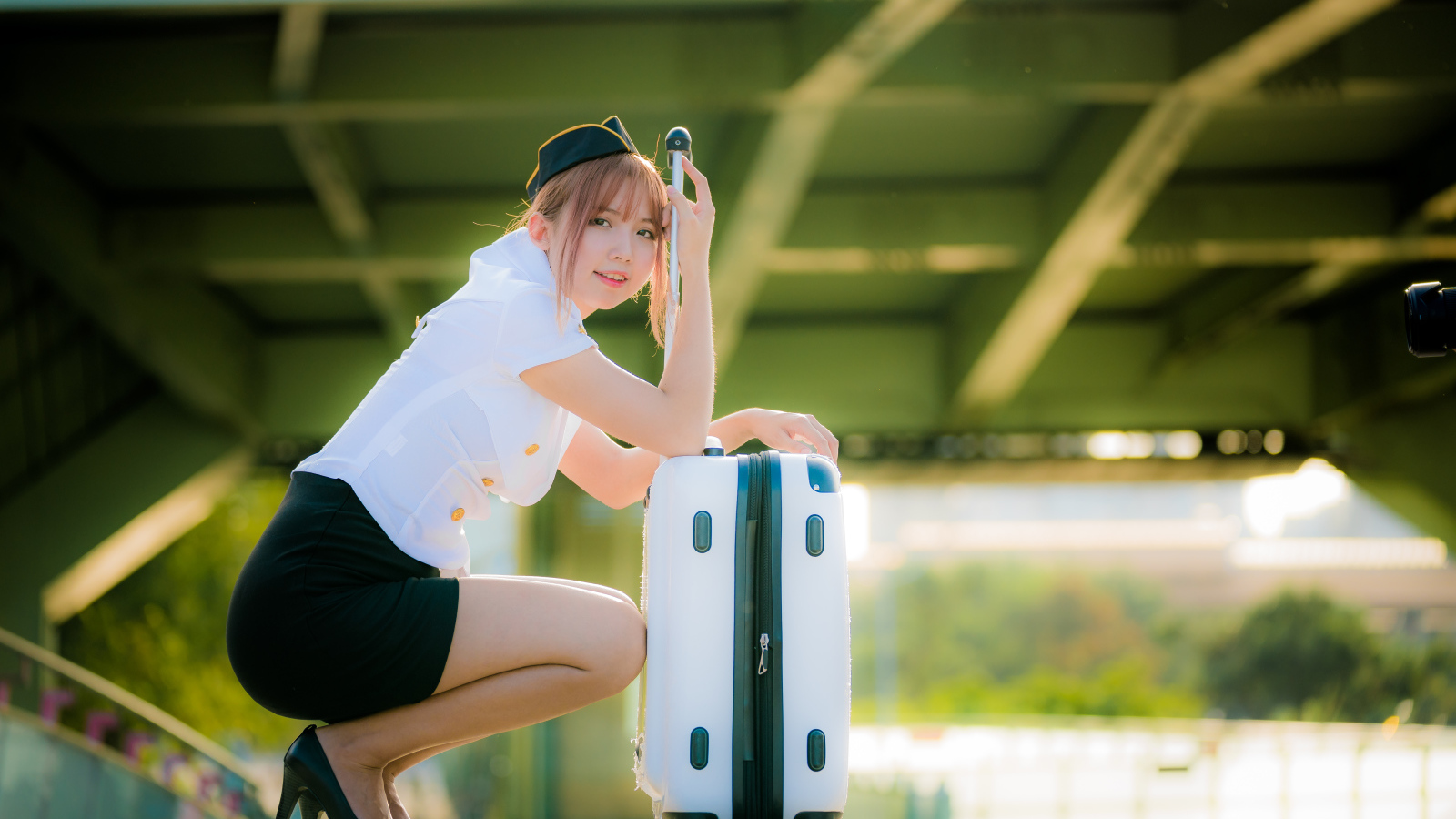 Девушка азиатка стюардесса с чемоданом