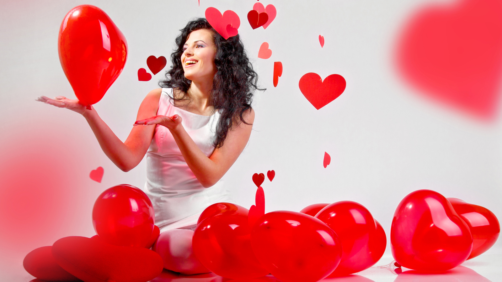 Красивая девушка брюнетка с воздушными шарами в форме сердца