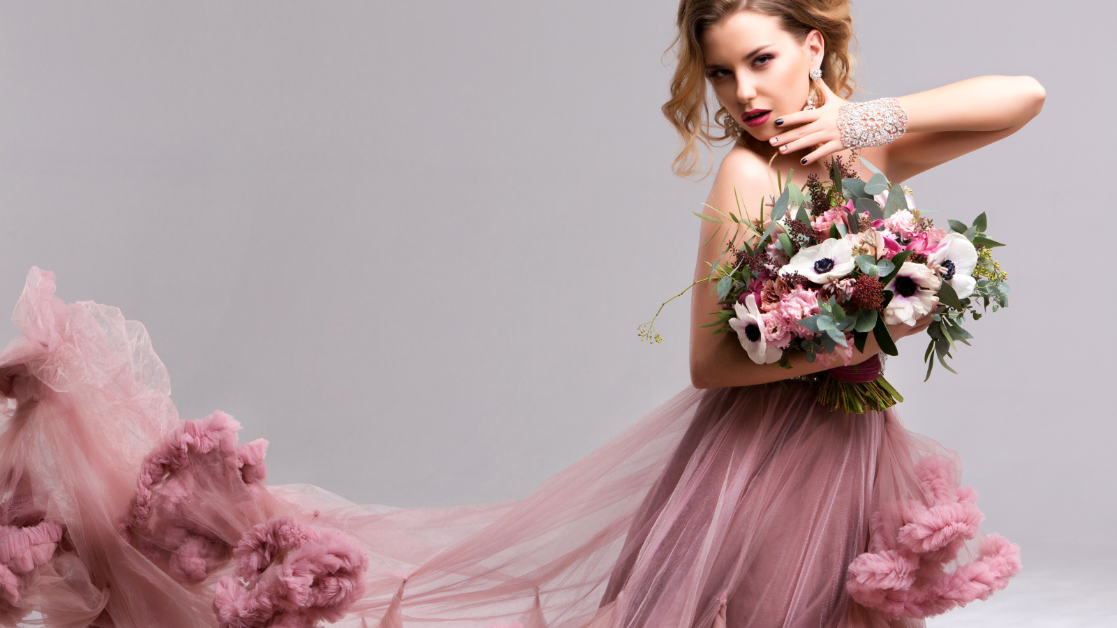 Эффектная девушка в красивом розовом платье с букетом цветов в руках
