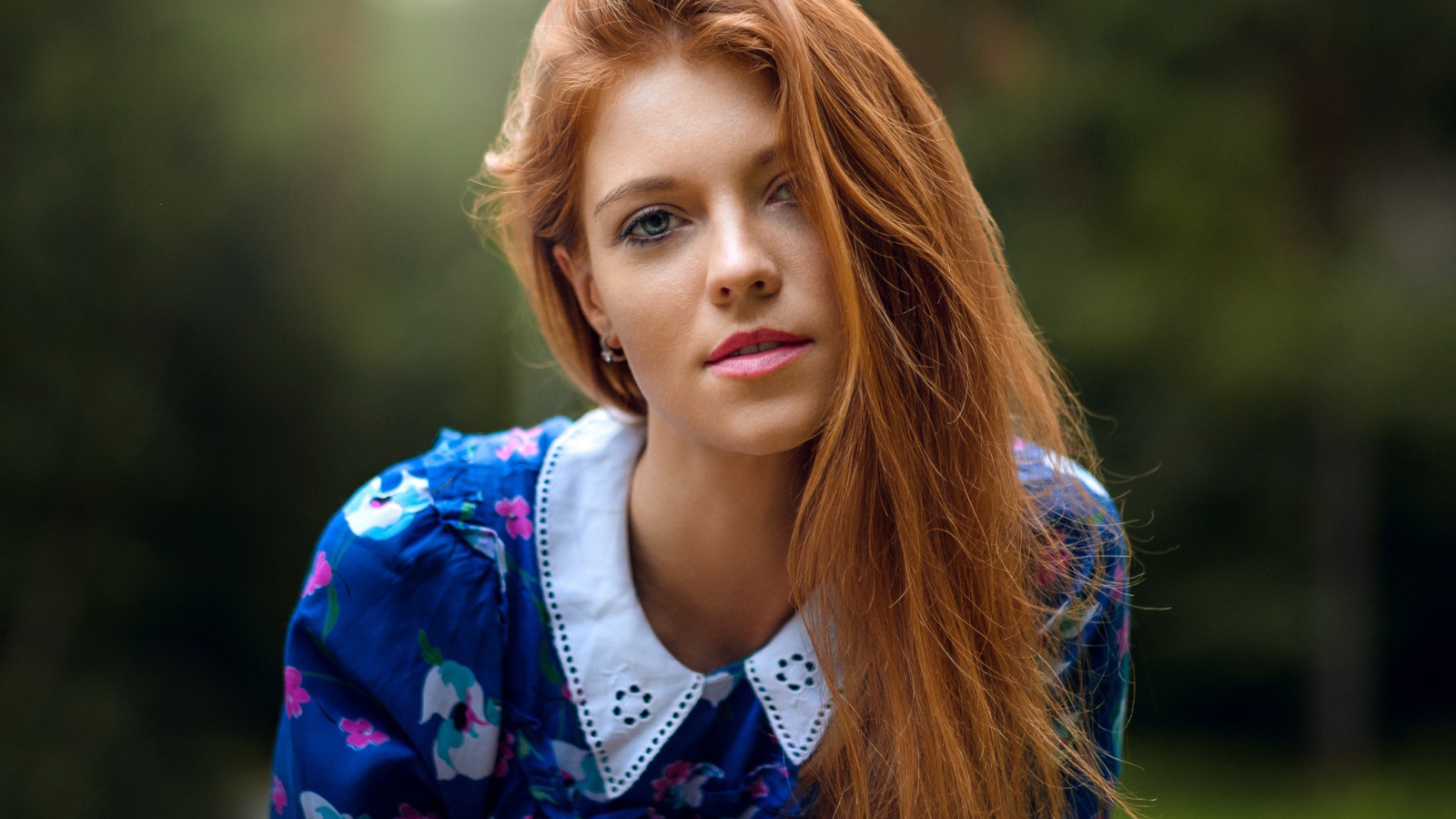 Красивая рыжеволосая девушка с зелеными глазами в красивом платье 