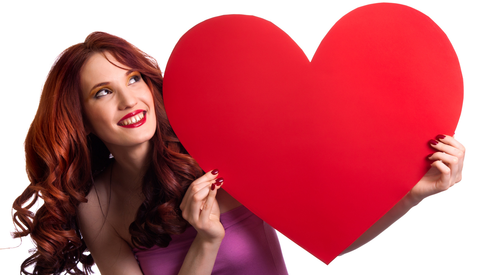 Красивая улыбающаяся девушка с большим красным сердцем в руках