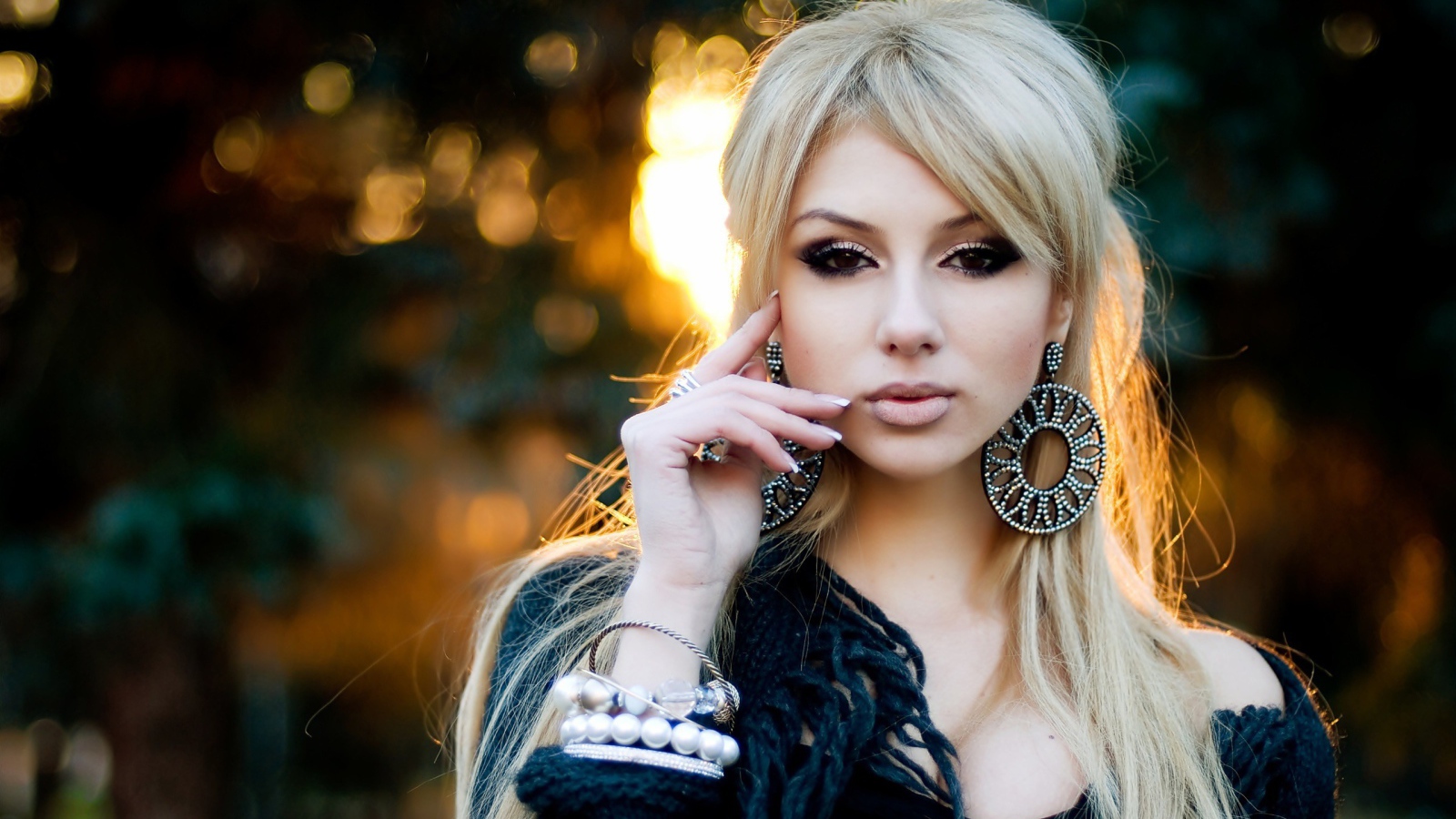 Девушка блондинка с большими серьгами в ушах 
