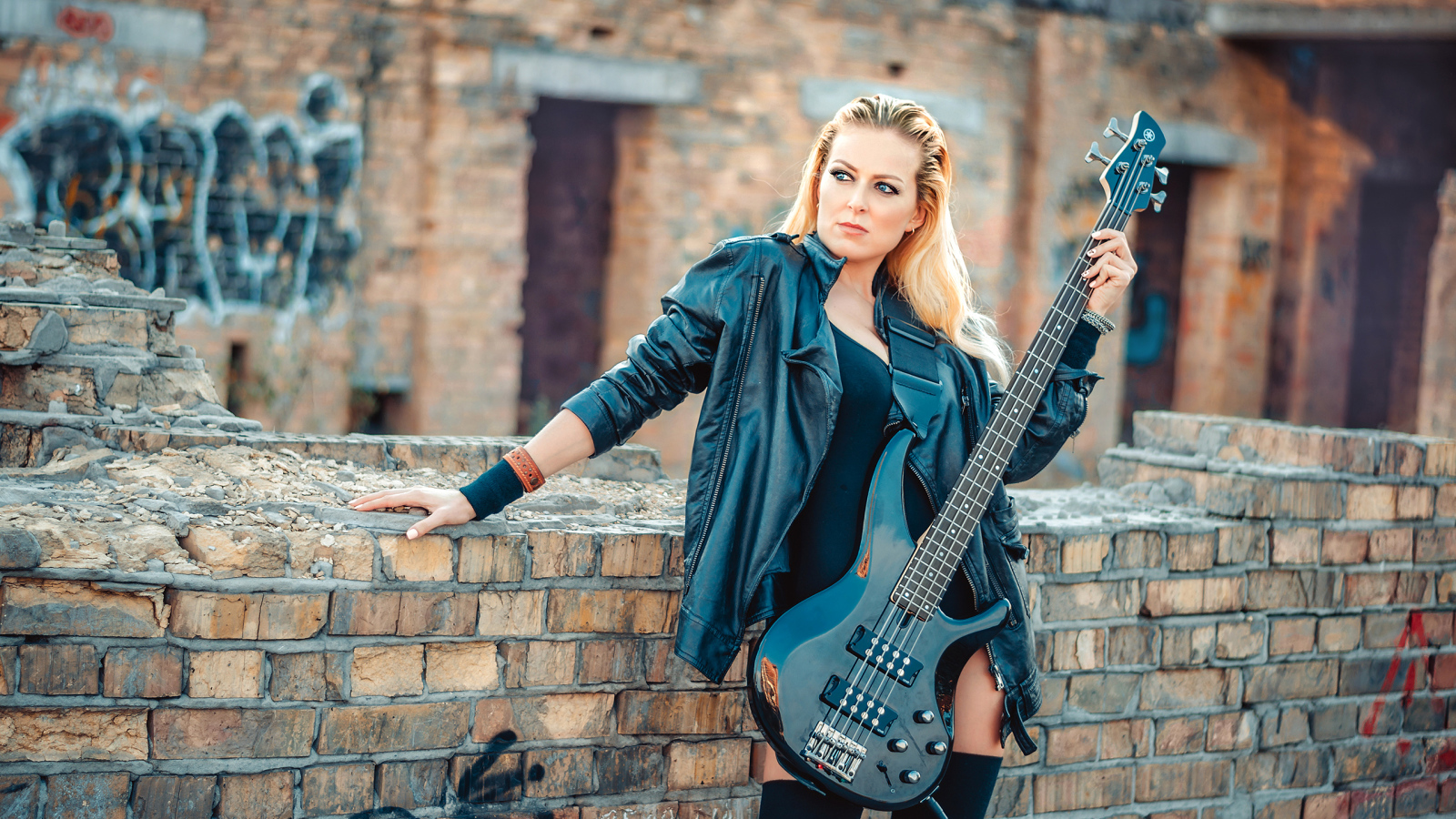 Блондинка в кожаной куртке с электрогитарой в руках
