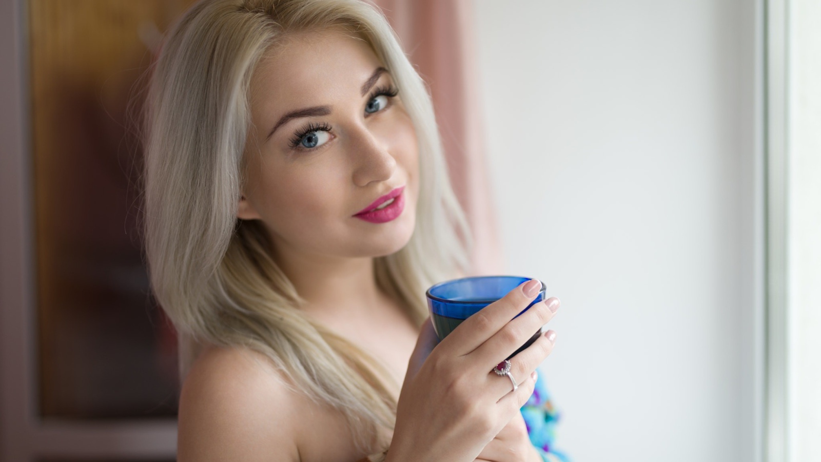 Блондинка с розовыми губами и стаканом в руках 