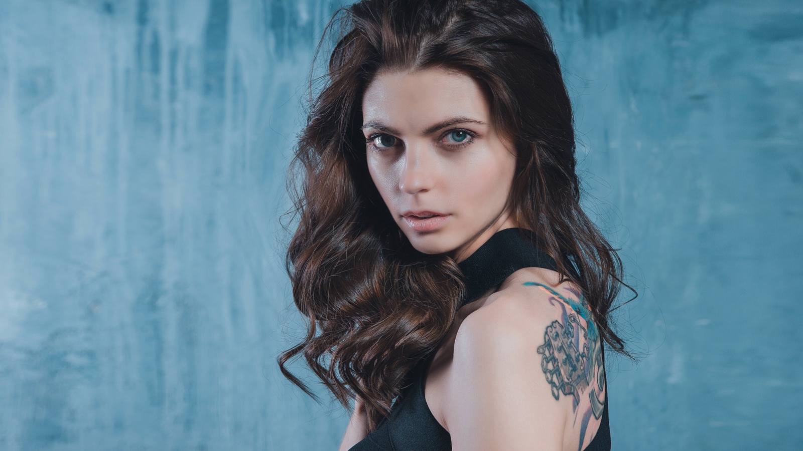 Голубоглазая девушка с татуировкой на спине 