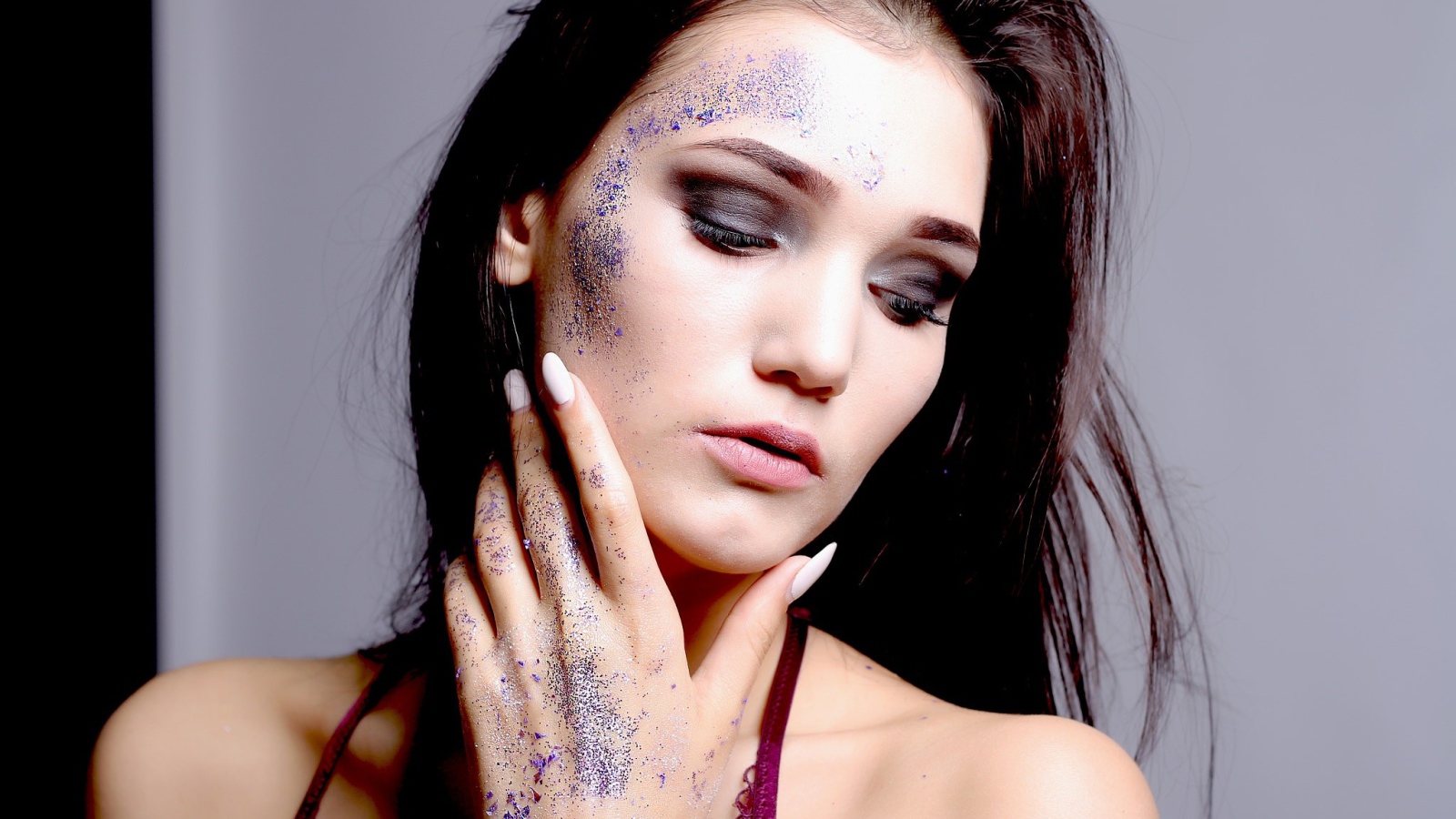 Брюнетка с блестками на лице 