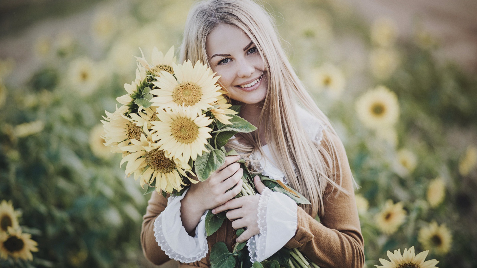 Милая улыбающаяся девушка с букетом цветов подсолнуха