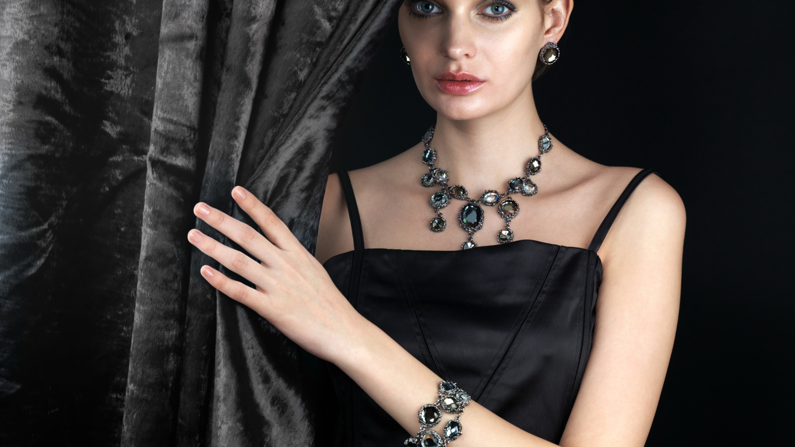 Эффектная девушка в черном платье и дорогих украшениях