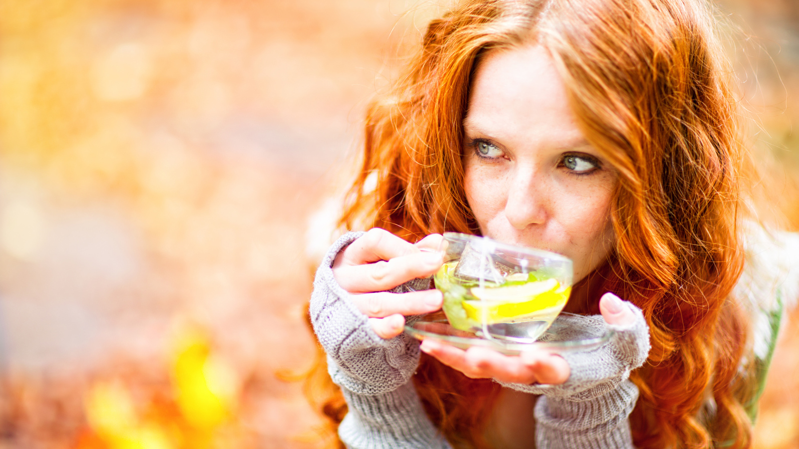 Рыжеволосая девушка модель с чашкой зеленого чая 