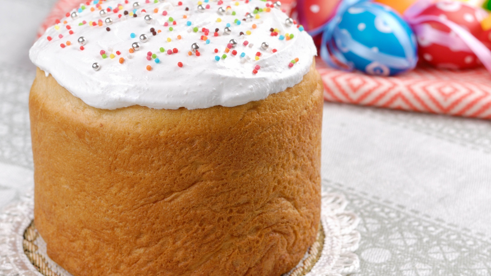 Пасхальный кулич с белой глазурью на столе 