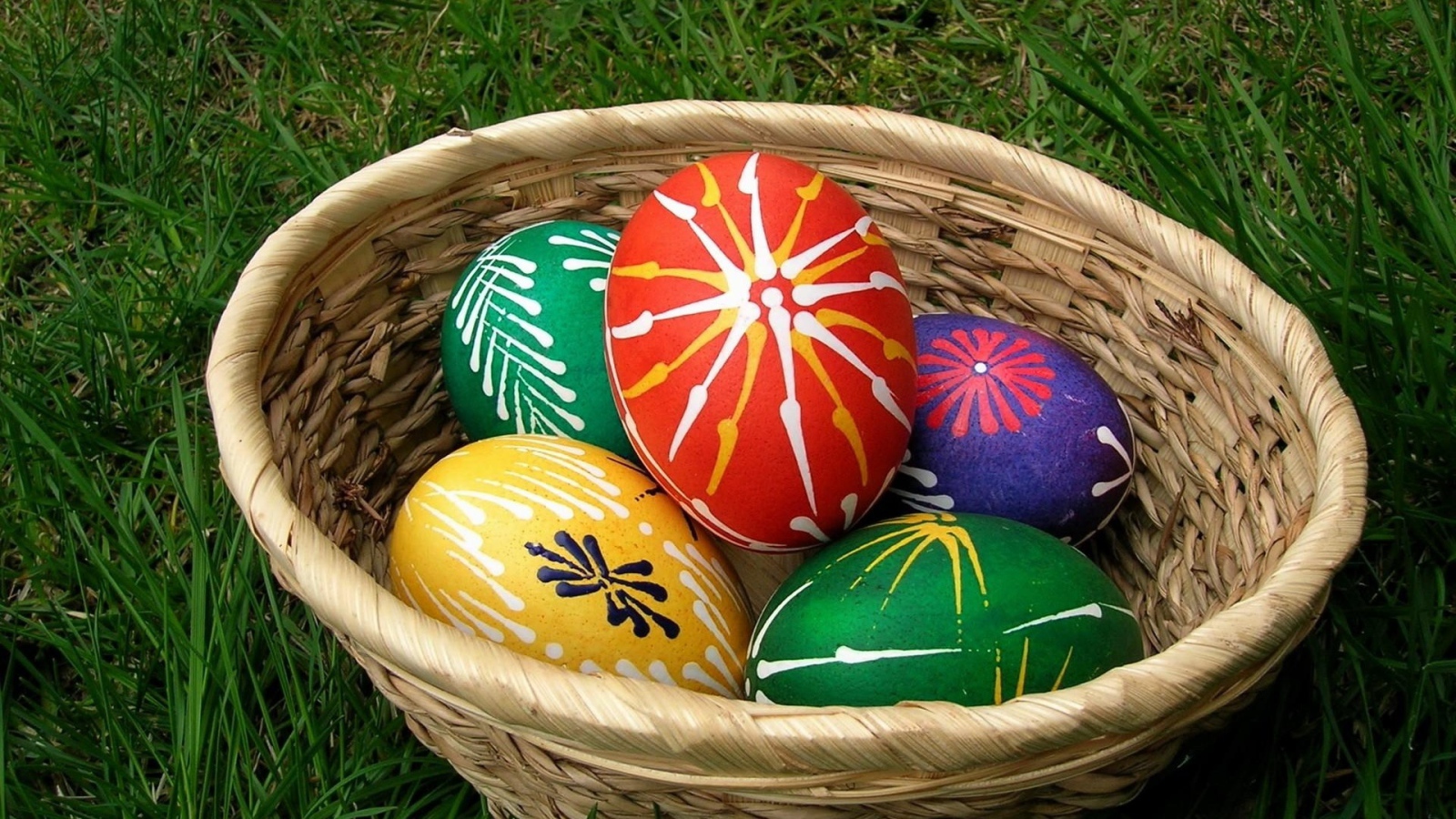 Пасхальные яйца с красивыми узорами в корзине 