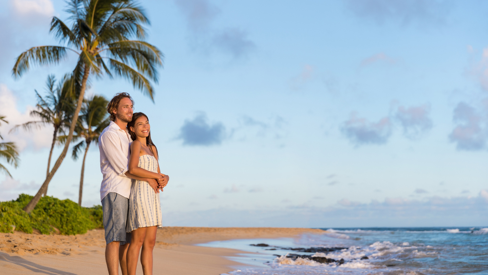 Влюбленная пара встречает закат на берегу океана