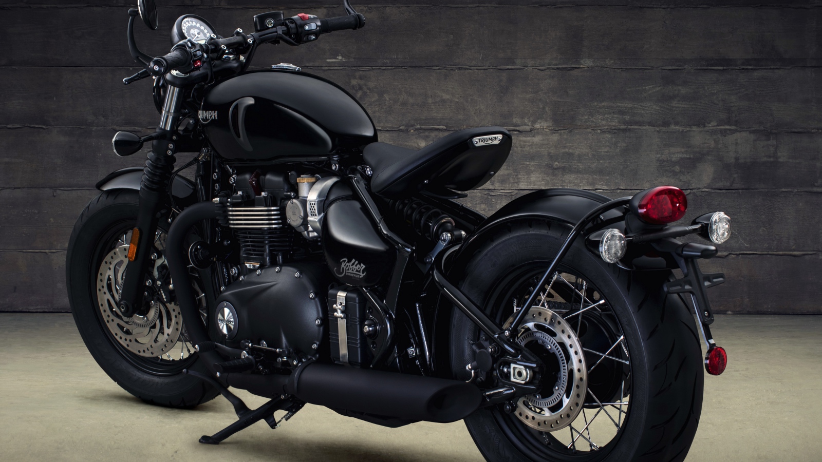 Черный мотоцикл Triumph Bonneville Bobber, 2018 вид сзади