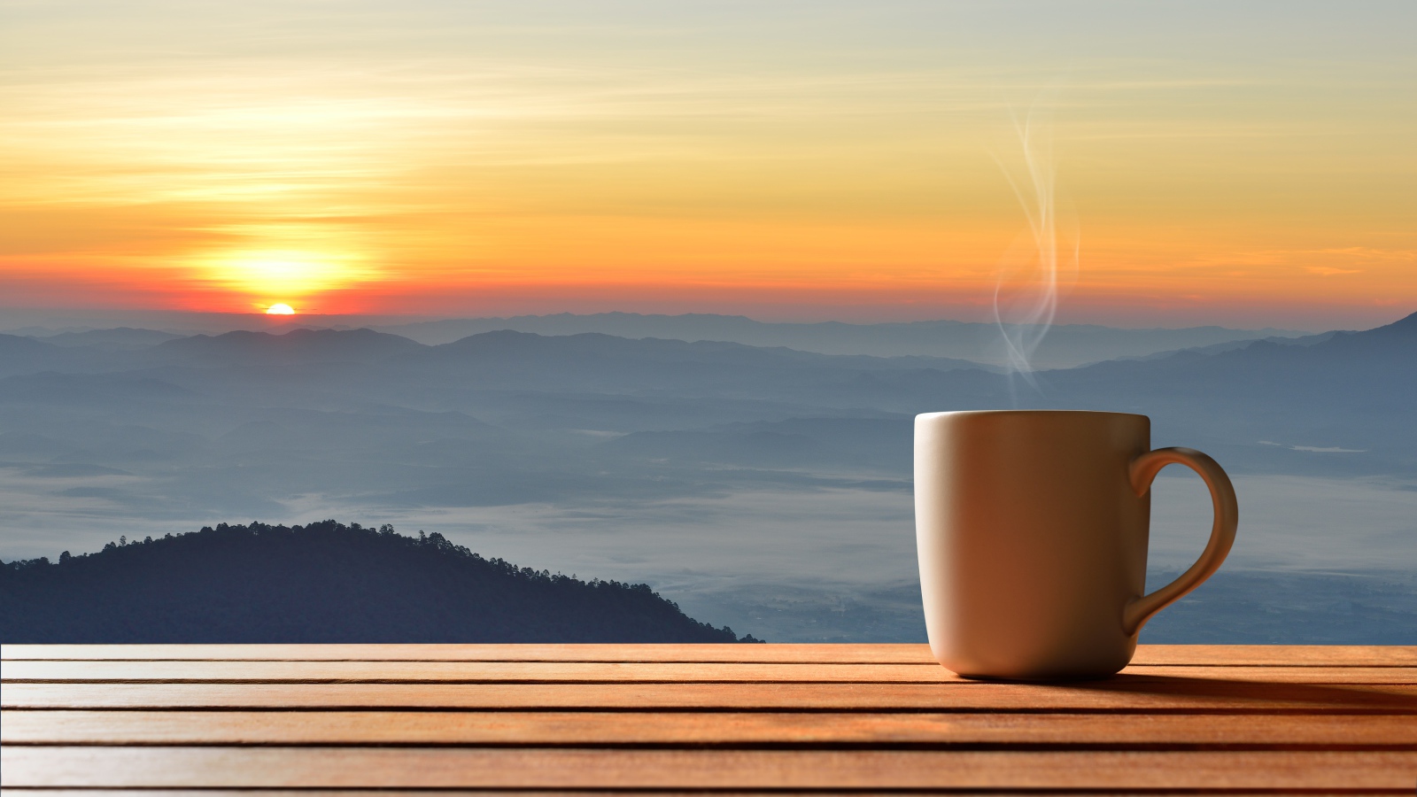 Чашка фоне на фоне горизонта с восходящим солнцем