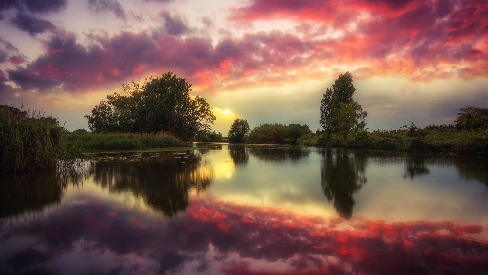 Красные облака отражаются в чистой воде реки