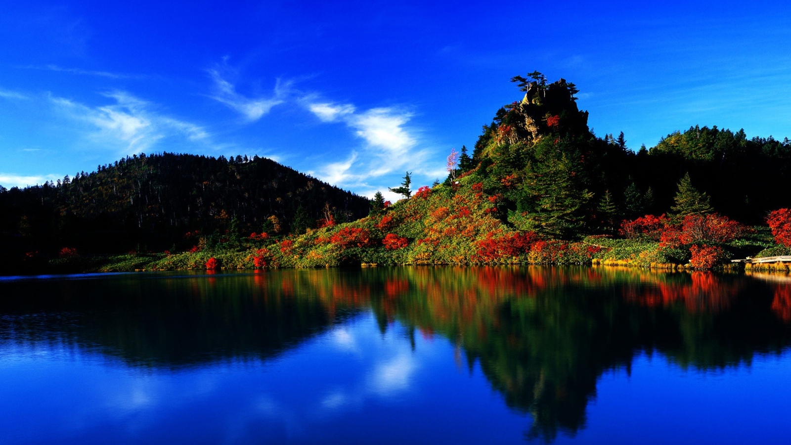 Голубое небо отражается в чистой воде озера 